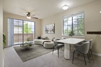 A living room with a white couch, a white coffee table, and a ceiling fan.